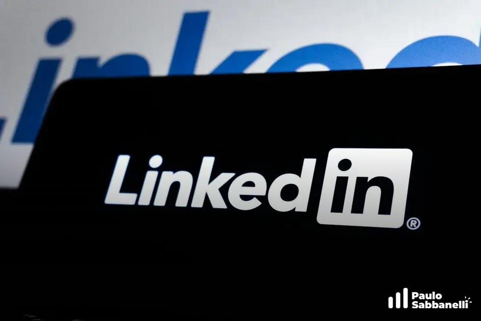 Tela de celular exibindo o logotipo branco do LinkedIn sobre fundo azul desfocado